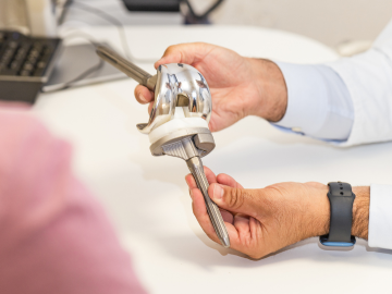 Close-up of hands holding and showcasing a prosthesis to a client.. It highlights the precision involved in working with Medical Devices, emphasizing the importance of quality and functionality involved.