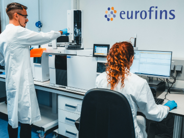 Two scientists in a Eurofins laboratory conducting Chromatography, showcasing advanced equipment and expertise in BioPharma Product Testing within a high-precision research environment.